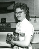 Janet Creek, 16, Rout 3, Billings, Montana is loaded down with canned foods, which she has selected to be used in making a meal for the Creek family.