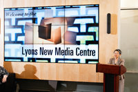 Margaret beside the large media wall in the Lyons New Media Centre