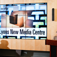 Margaret beside the large media wall in the Lyons New Media Centre